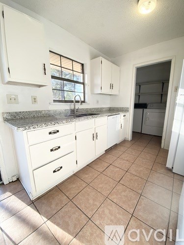 A kitchen with white cabinets and a granite countertop.