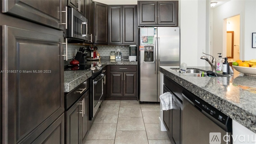 A kitchen with dark brown cabinets and stainless steel appliances.