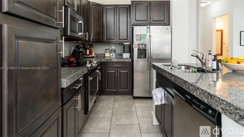 A kitchen with dark brown cabinets and stainless steel appliances.