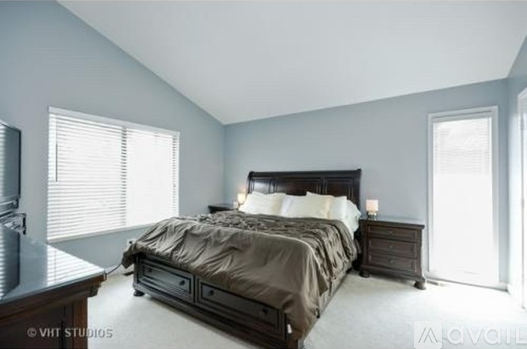 A bedroom with a bed, nightstand, and window.