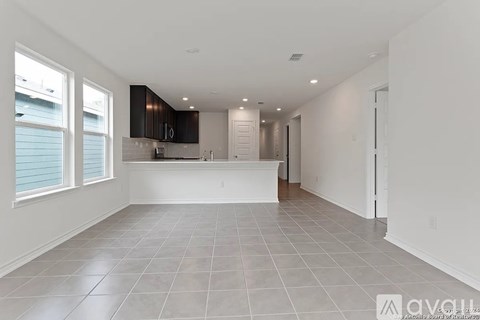 A spacious kitchen with white cabinets and a large island.