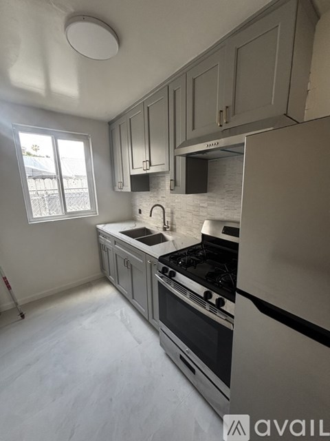 A kitchen with a white countertop and grey cabinets.