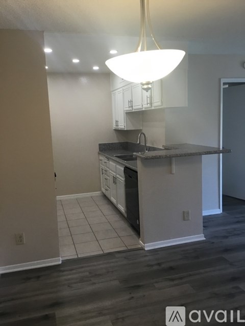 A kitchen with a black countertop and white cabinets.