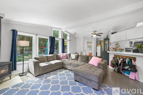 A living room with a grey couch and a blue rug.