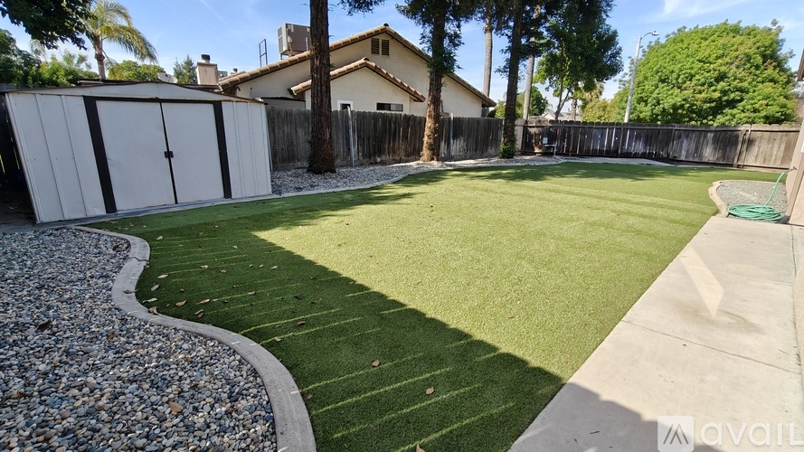 A backyard with a grassy area and a gravel path.