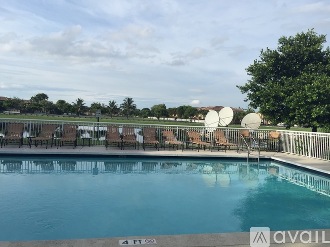 A pool with chairs and a sign that says "4 FT" on the side.