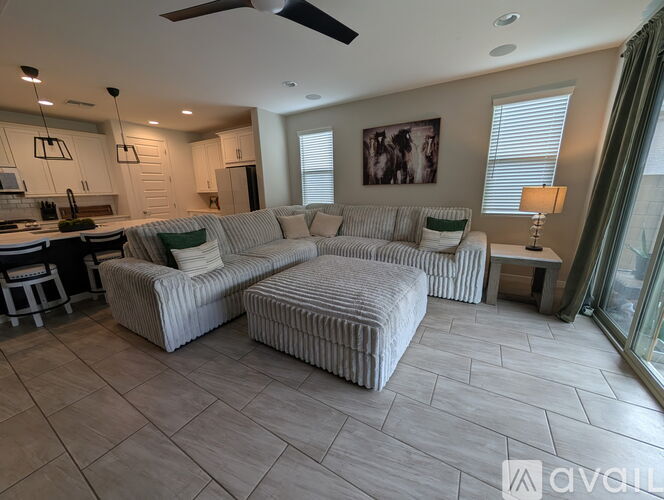 A living room with a striped couch and a ceiling fan.