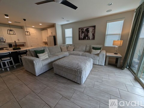 A living room with a striped couch and a ceiling fan.