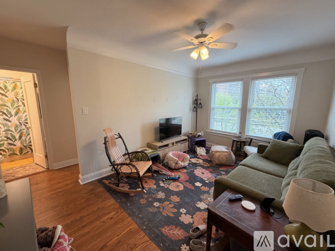 A living room with a television, a couch, and a rug.