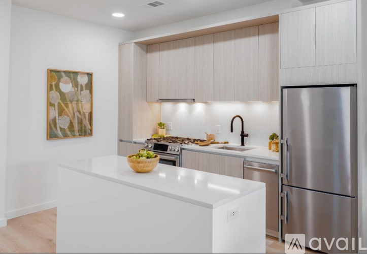 A modern kitchen with a stainless steel refrigerator and a white countertop.