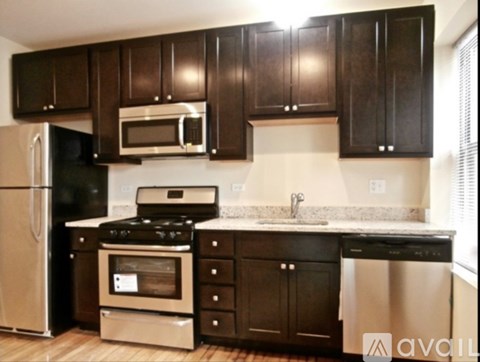 A kitchen with black cabinets and stainless steel appliances.