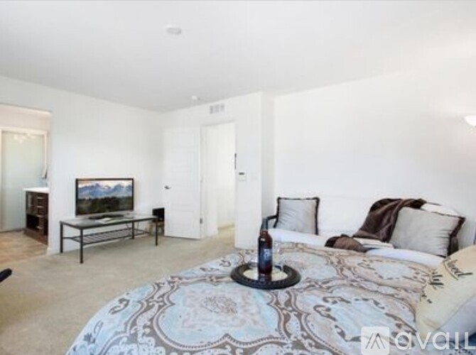 A bedroom with a large bed and a painting on the wall.