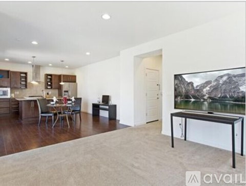 A modern living room with a television and a dining table.