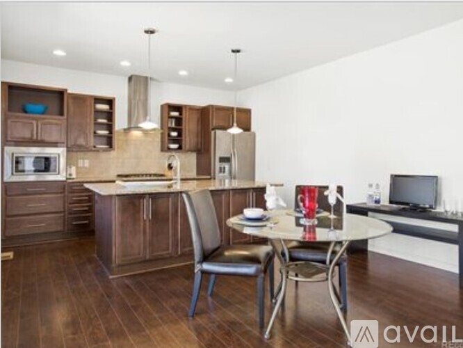 A modern kitchen with dark wood floors and a white ceiling.
