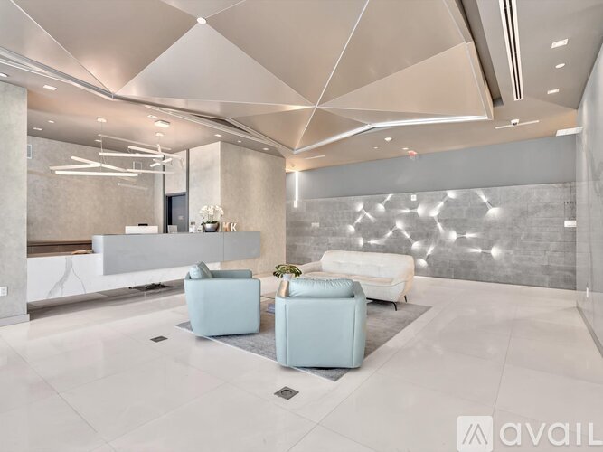 A modern living room with a white sofa and a light blue armchair.
