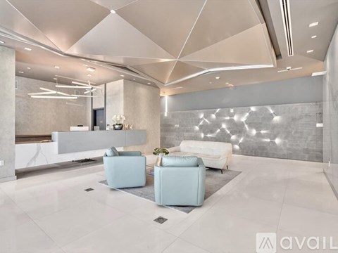 A modern living room with a white sofa and a light blue armchair.