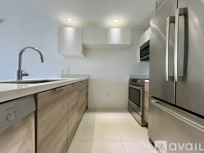 A modern kitchen with stainless steel appliances and wooden cabinets.