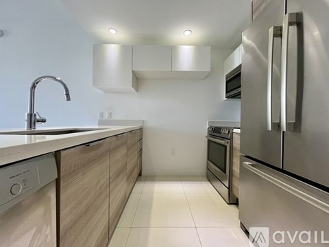 A modern kitchen with stainless steel appliances and wooden cabinets.