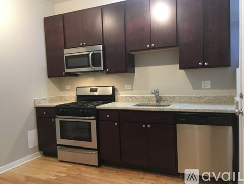 A kitchen with dark brown cabinets and stainless steel appliances.