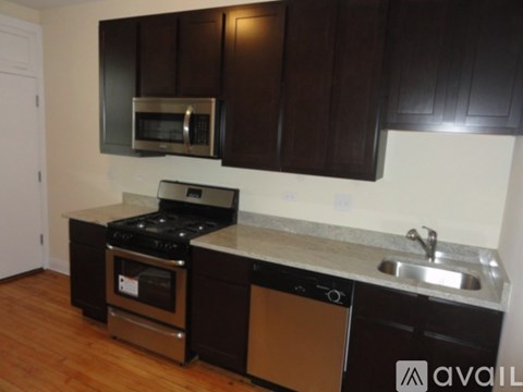 A kitchen with dark brown cabinets and stainless steel appliances.