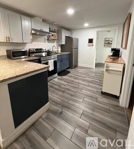 A kitchen with black cabinets and a tiled floor.