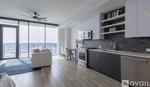 A modern kitchen with a dining table and chairs, a sofa, and a view of the city.