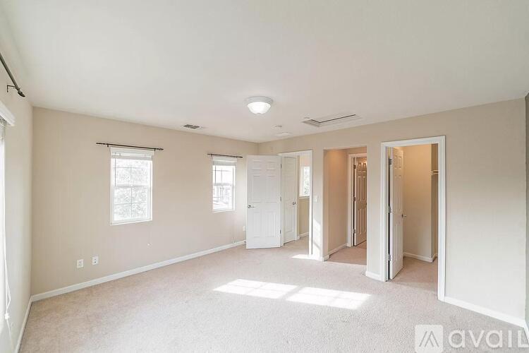 A spacious room with a carpeted floor and white walls.