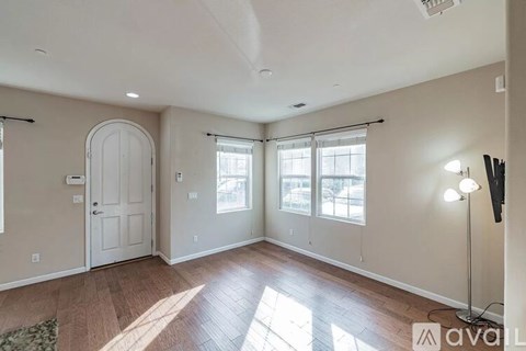 A living room with a door, a window, and a lamp.