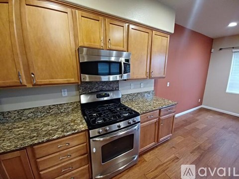 A kitchen with wooden cabinets and granite countertops.