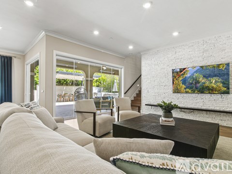 A living room with a white couch and a painting on the wall.