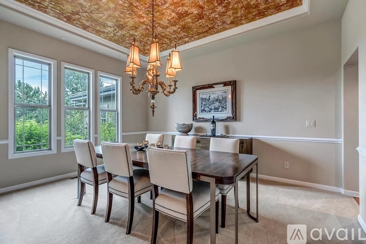 A dining room with a wooden table and chairs.