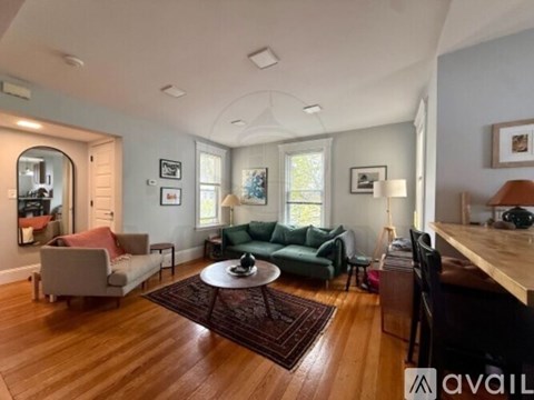 A living room with a green couch and a wooden floor.