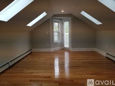 A room with wooden floors and skylights.