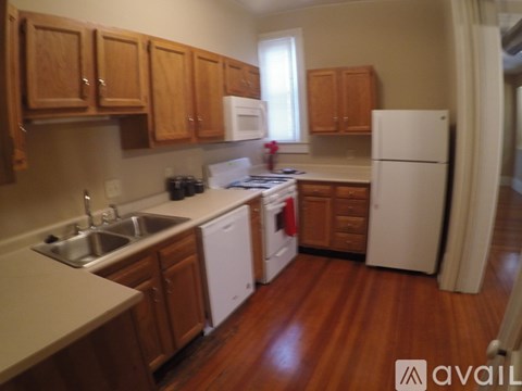 A kitchen with wooden cabinets and a white fridge.