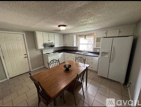 A kitchen with a table and chairs in the middle of the room.