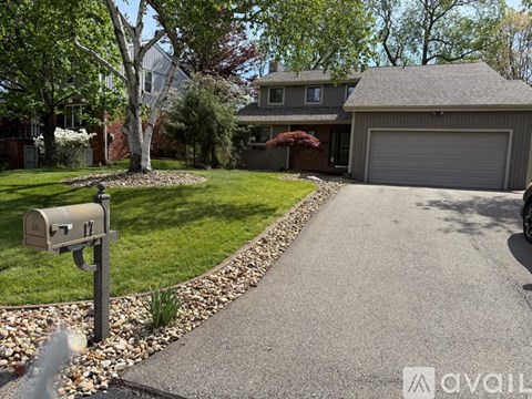 A residential house with a driveway and a mailbox.