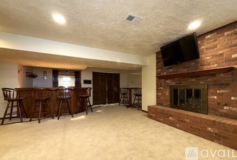 A living room with a fireplace and a television mounted above it.