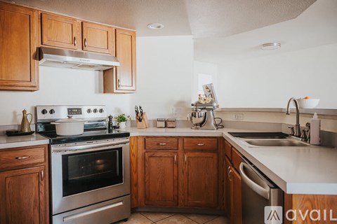 A kitchen with wooden cabinets and stainless steel appliances.