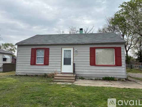 A small house with a red door and red window trim.