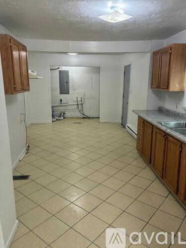 A kitchen with wooden cabinets and a tiled floor.