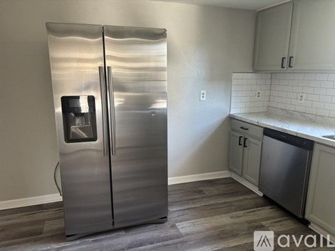 A stainless steel refrigerator with its door open in a kitchen.
