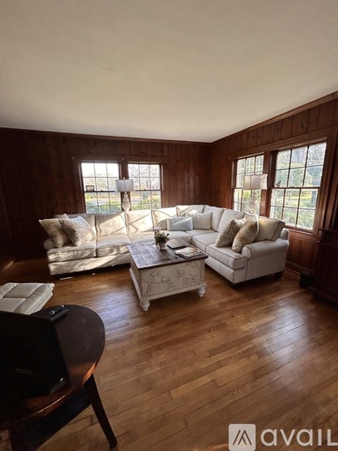 A living room with white furniture and wooden floors.