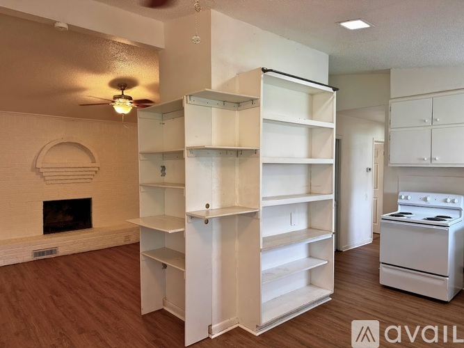 A living room with a fireplace and built-in shelves.