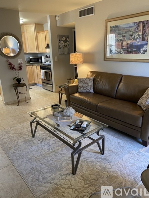 A living room with a couch, coffee table, and a painting on the wall.