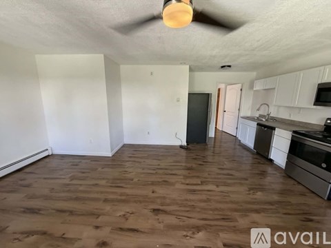A room with wooden flooring and a ceiling fan.