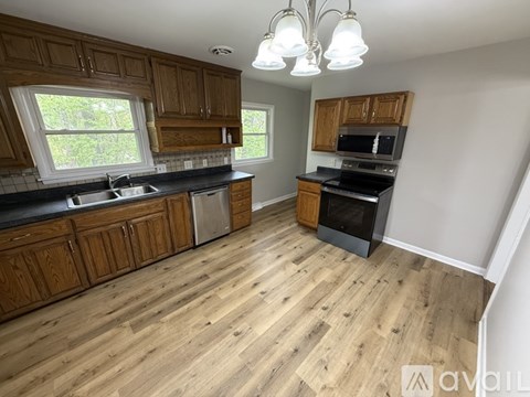 A kitchen with wooden cabinets and a black countertop.
