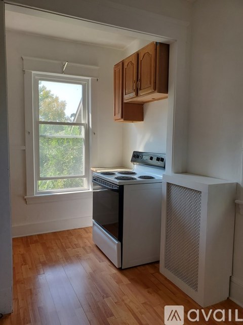 A kitchen with wooden floors and white walls.