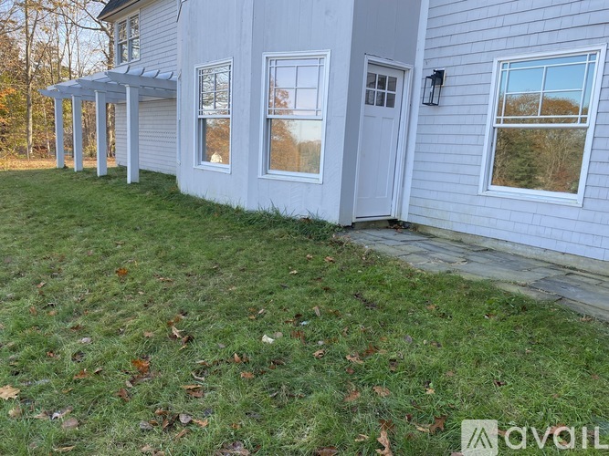 A house with a white siding and a grey door.