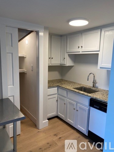 A kitchen with white cabinets and a granite countertop.
