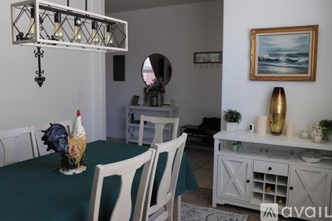 A kitchen with a granite countertop and wooden chairs.